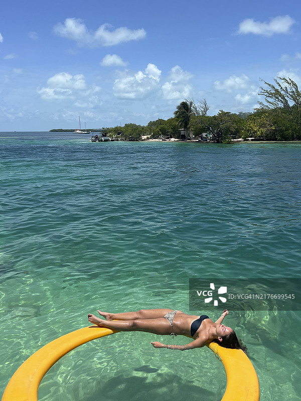 少女在海中漂浮，享受日光浴图片素材
