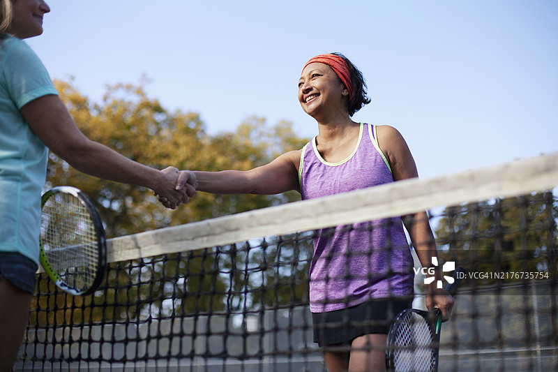 网球比赛后，亚洲中年妇女与对手握手图片素材