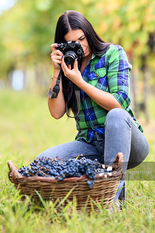 在葡萄园里用模拟相机拍摄的美丽女摄影师图片素材