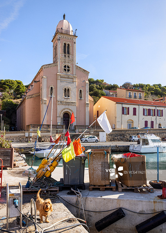 港口的狗和五彩缤纷的浮标。法国奥克西塔尼大区的波尔特-旺德尔斯。图片素材