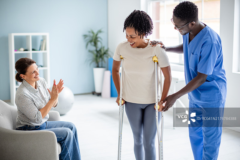 支持性的治疗师帮助病人使用拐杖行走图片素材