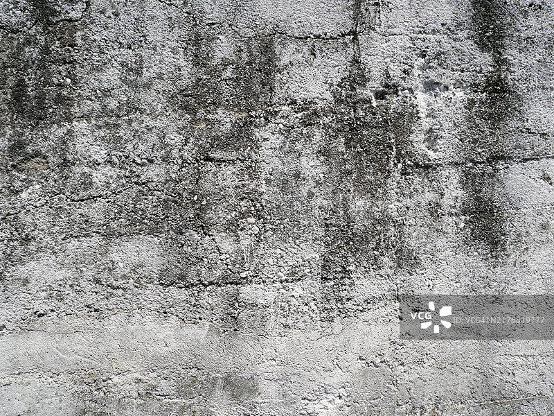 破裂的灰色混凝土墙。粗糙的纹理。阳光。自然色彩和风化效果。葡萄牙，波尔图。图片素材