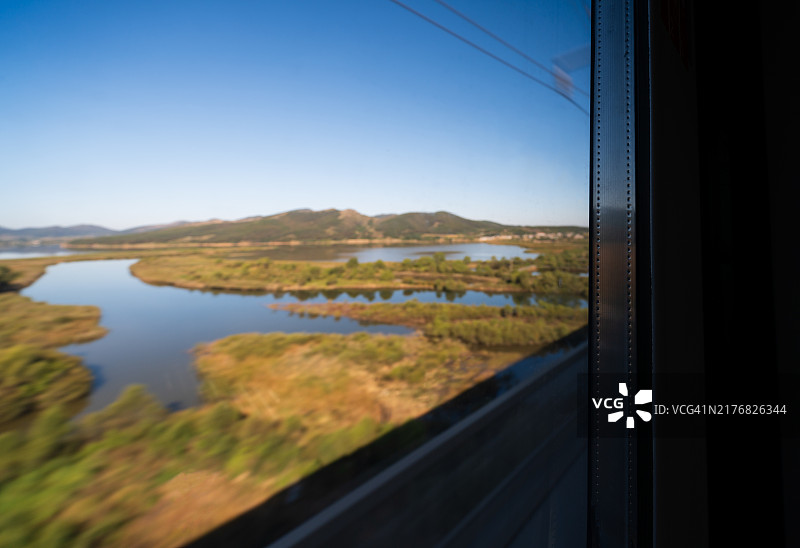 从火车车窗看到的风景如画的河流和蓝天下的景色图片素材