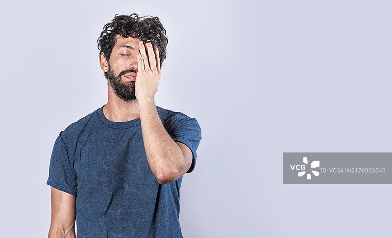 疲惫绝望的男人用手掌捂住脸，一个感到无聊和疲惫的男人图片素材