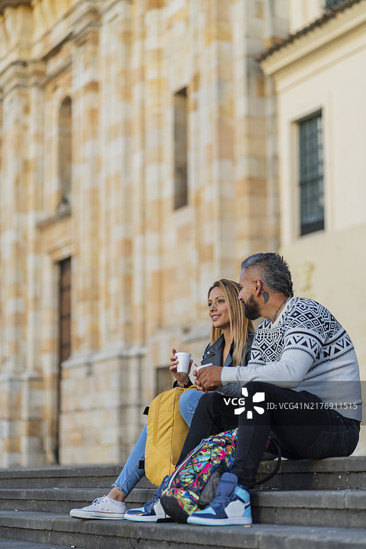 美丽的情侣在拉坎德拉里亚的博利瓦尔广场享受美好的时光，同时品尝美味的热饮。图片素材