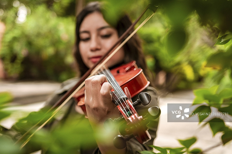 户外演奏小提琴的微笑女孩图片素材