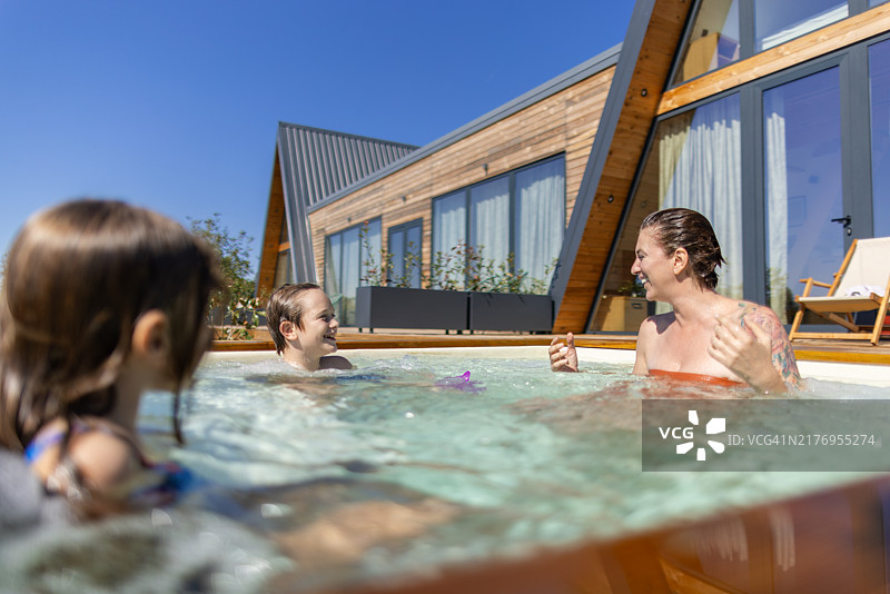 母亲和两个孩子在热水浴缸里玩耍图片素材