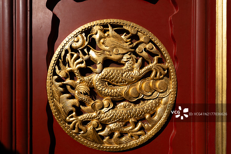 红色木门上的金色龙纹圆形浮雕图片素材