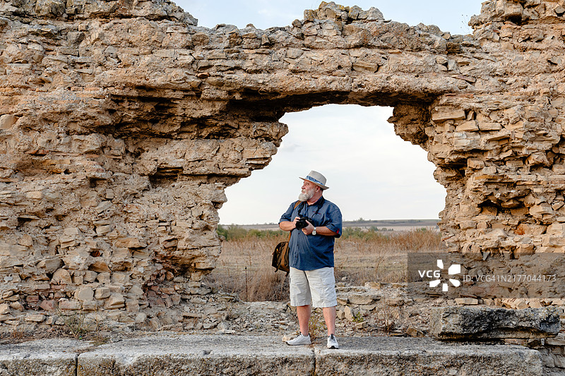 老年摄影师用相机拍摄古遗址图片素材