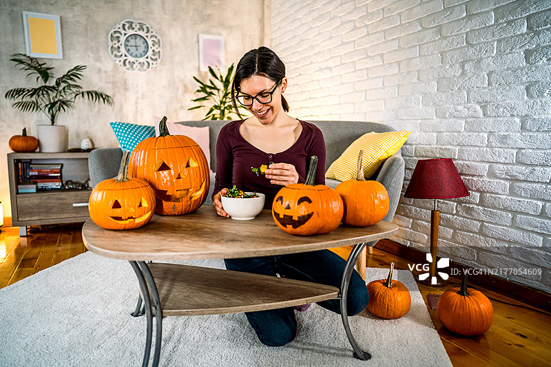 女人在家吃万圣节糖果图片素材