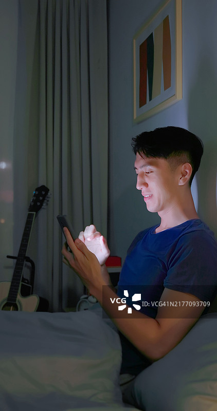 男人滑动智能手机在黑暗中图片素材