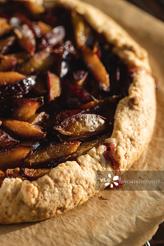 烤盘上羊皮纸上的李子馅饼。特写镜头。图片素材