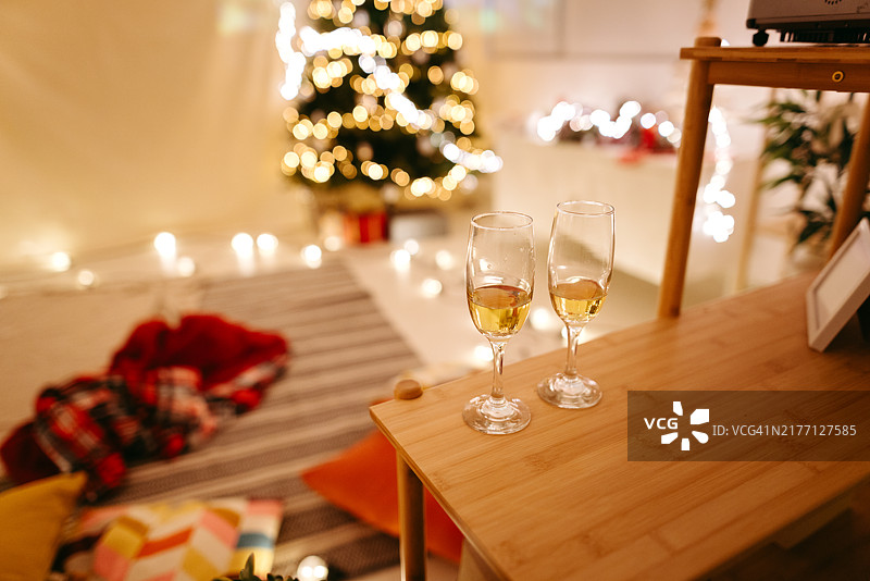 圣诞节浪漫约会之夜装饰房间里的桌子上放着两个白葡萄酒杯图片素材