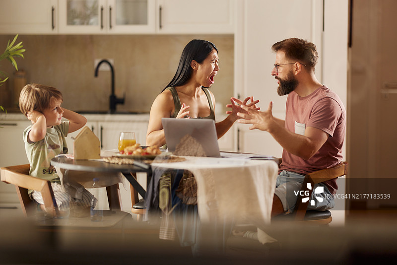 在餐厅里争吵的沮丧父母和小儿子图片素材