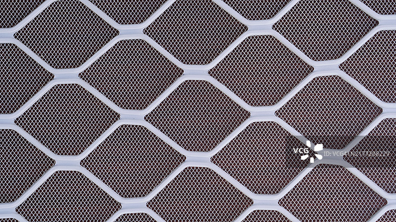 木质背景上的白色金属丝网围栏图片素材