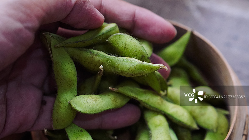 竹篮中的毛豆和用手吃的日本料理图片素材