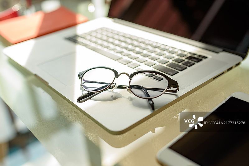 带笔记本的桌子上的眼镜特写图片素材