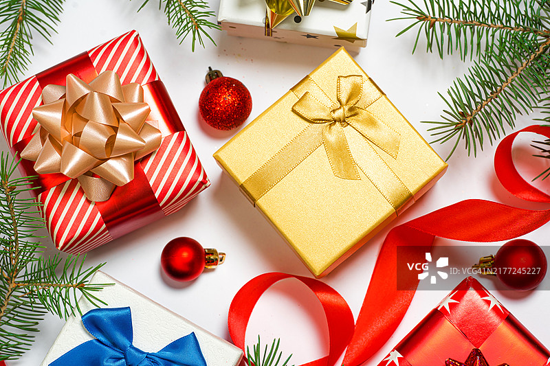 圣诞节礼物盒。冬季节日和黑色星期五概念，含DIY包装礼盒、圣诞树枝、红丝带和圣诞球图片素材