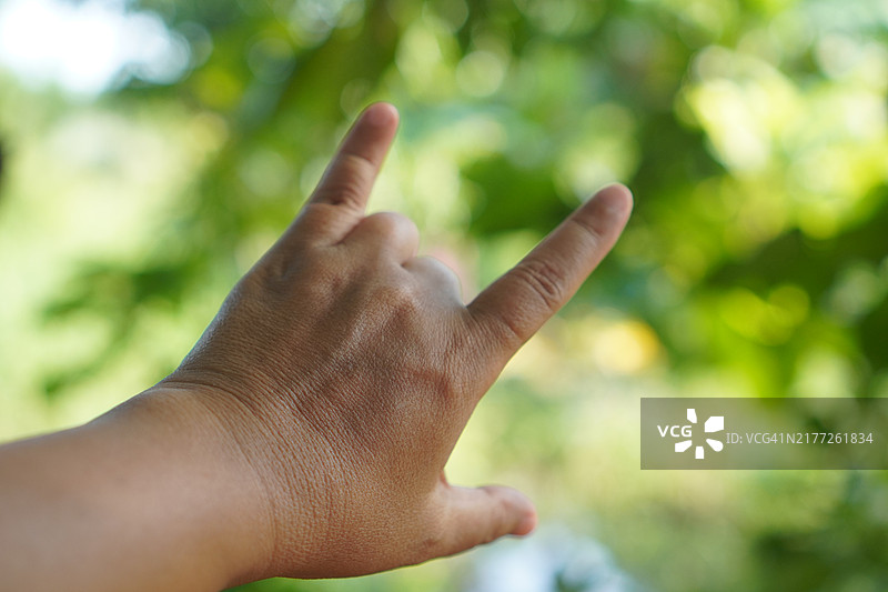 亚洲女性手部特写，做出心形，表达爱意的手语，手臂和手在白色背景上，有我爱你的符号留白图片素材