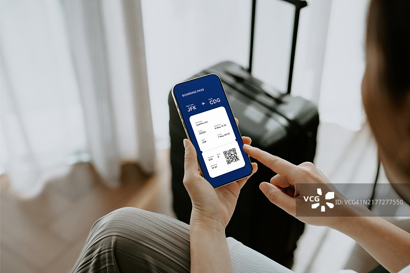 亚洲年轻女子展示手机上的电子机票和登机牌图片素材