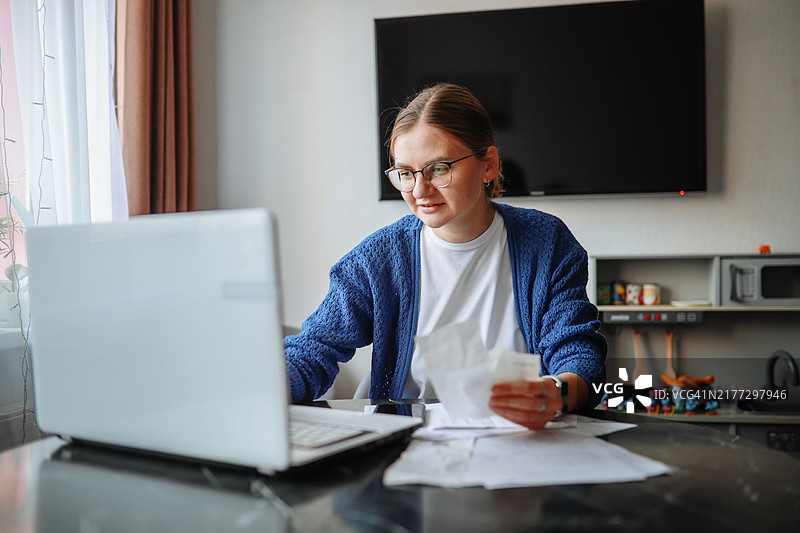 账单支付：女人使用笔记本电脑和支票管理财务图片素材