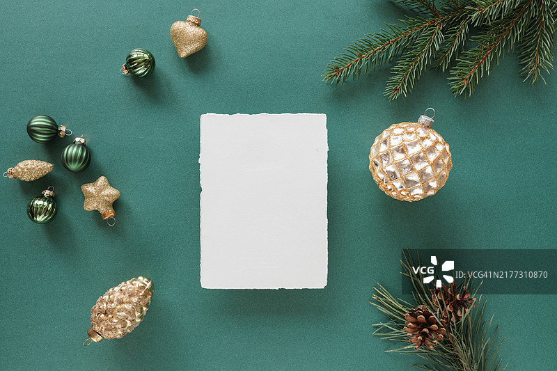 绿色背景上带有圣诞装饰品和松枝的毛边卡片俯视图图片素材