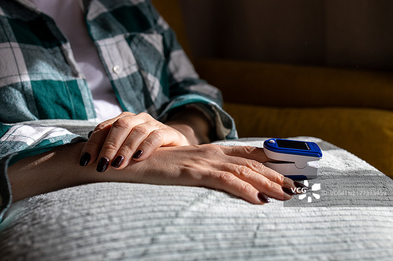 在家使用脉搏血氧仪的女子图片素材