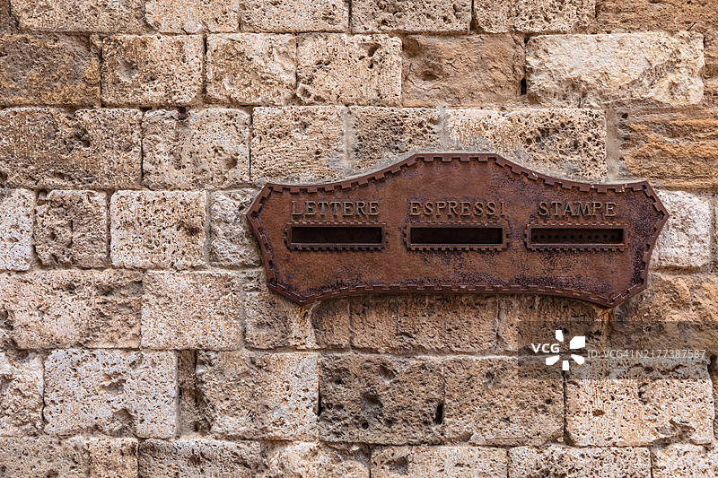 意大利托斯卡纳圣吉米尼亚诺古老石墙上的生锈邮箱图片素材