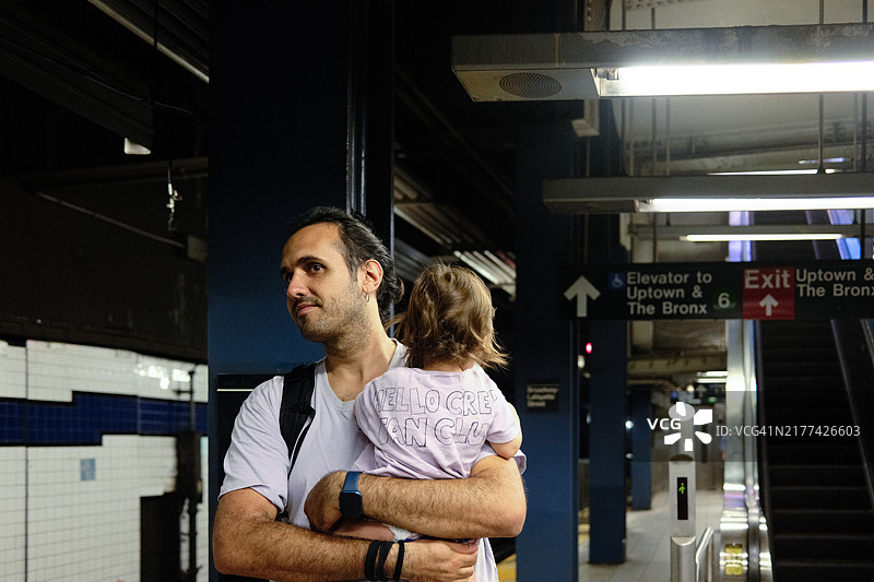 父亲抱着儿子等待地铁列车图片素材