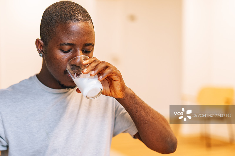 年轻黑人男性正在喝牛奶图片素材