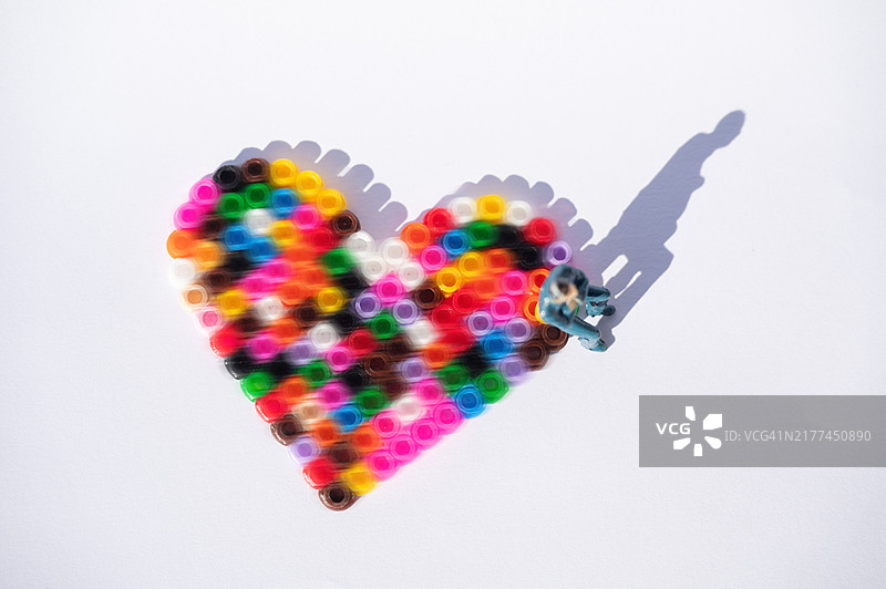 坐在彩色心形上的男人雕像图片素材