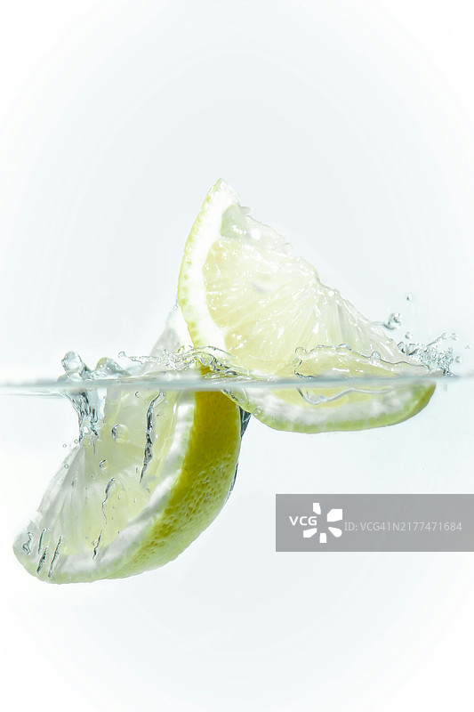 白色背景下水中柠檬片的特写图片素材