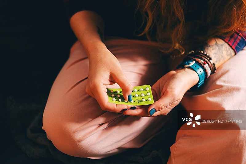 女人在家手持避孕药图片素材