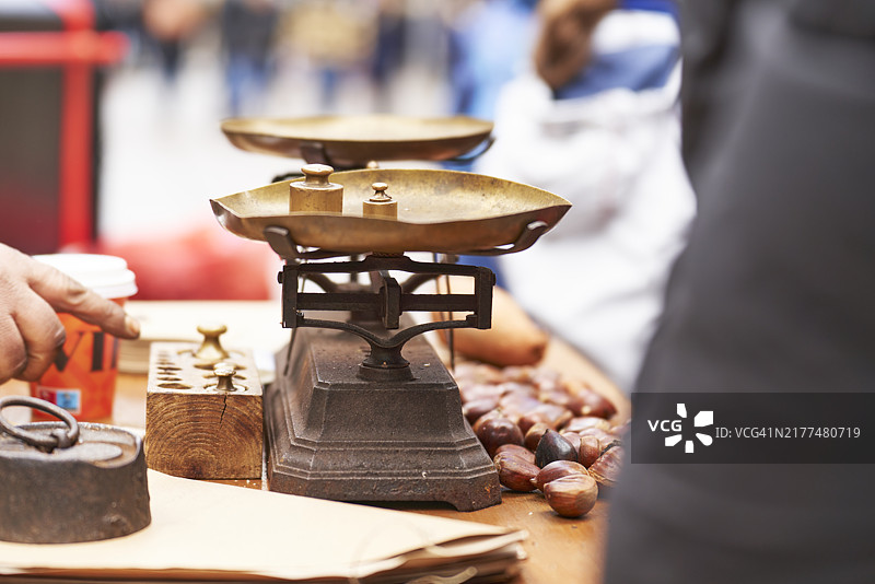 城市木桌上的老式秤和栗子图片素材