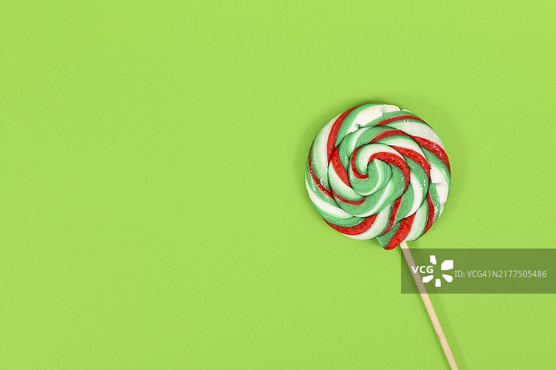 圣诞节配色的棒棒糖，绿色背景留白图片素材