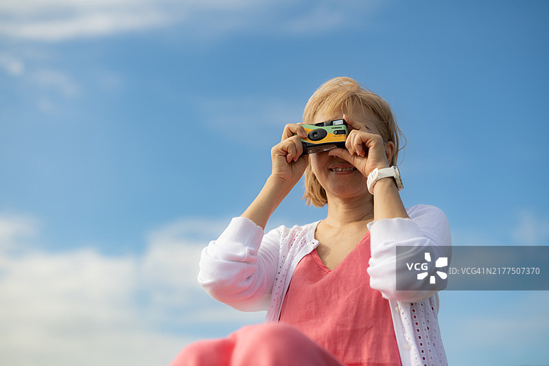 用一次性相机拍照的女人图片素材