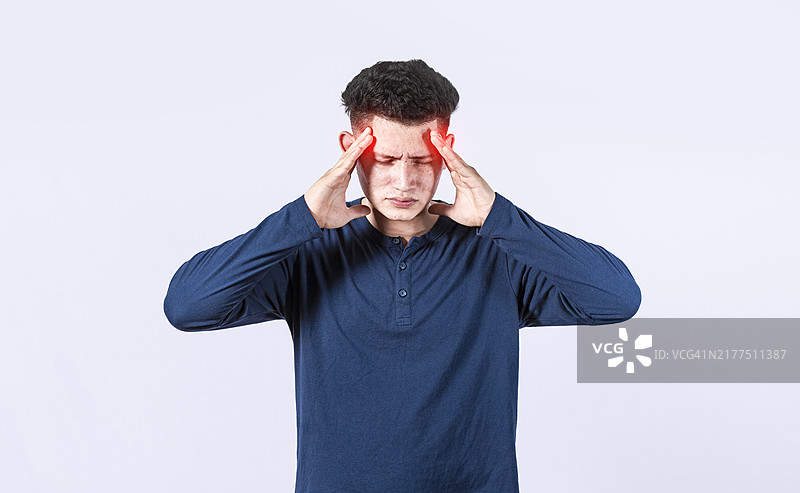 头痛男子概念：男子在孤立背景下揉搓头部，给自己头部按摩，偏头痛概念图片素材