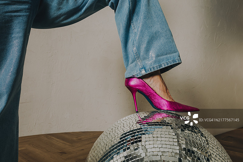 闪亮迪斯科球上的时尚粉色高跟鞋和牛仔裤图片素材