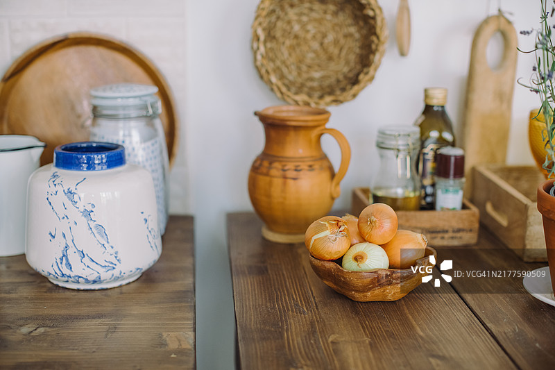 厨房桌子上放着洋葱碗，以及各种罐子、碗和炊具图片素材