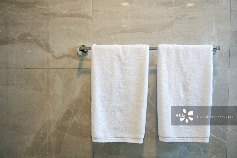 白色毛巾挂在浴室的镀铬毛巾架上图片素材
