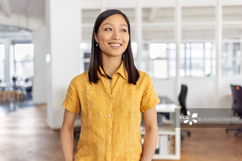 自信的年轻女性专业人士微笑着望向远方图片素材