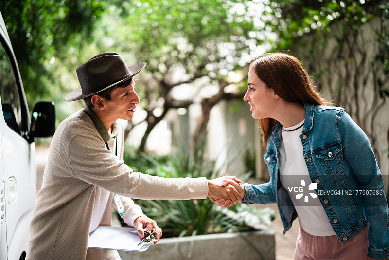 中年男导游迎接进入旅游面包车的游客图片素材