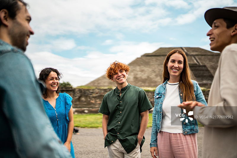 导游在墨西哥特奥蒂瓦坎金字塔前与游客交谈图片素材