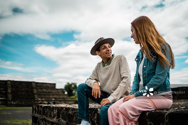 在墨西哥特奥蒂瓦坎金字塔上交谈的情侣图片素材