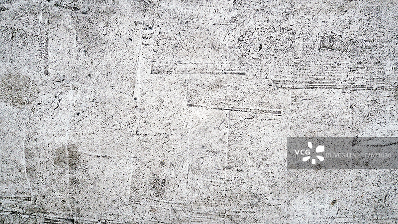 巴黎，法国一面灰色水泥墙的特写，涂成白色并经过风化处理。粗糙的纹理。阳光。自然色彩。图片素材