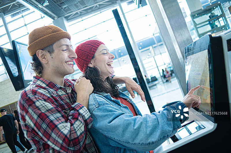 幸福的夫妇在机场自助办理登机手续图片素材