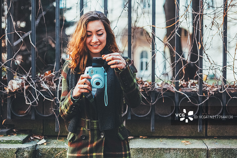 年轻女子使用一次成像相机肖像图片素材