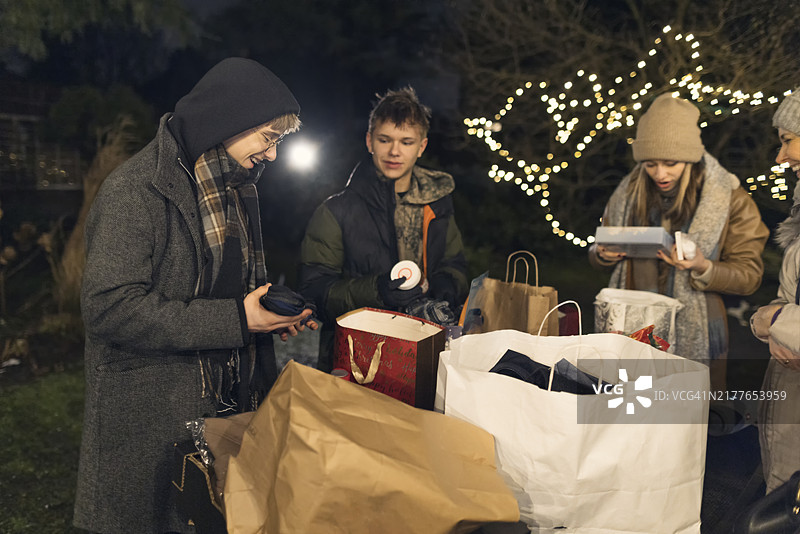 多代同堂家庭在圣诞前夜于后院分享礼物图片素材