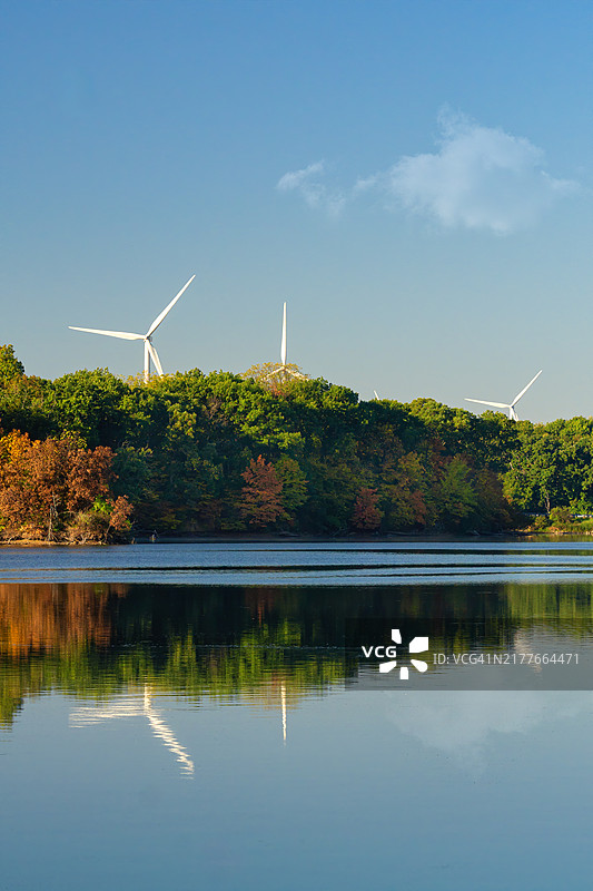 秋天蓝色湖面上倒映的风力涡轮机图片素材