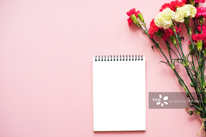 粉色背景上带有鲜花的记事本图片素材